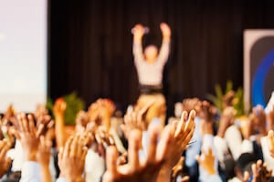 Personnes et animateur conférence levant la main